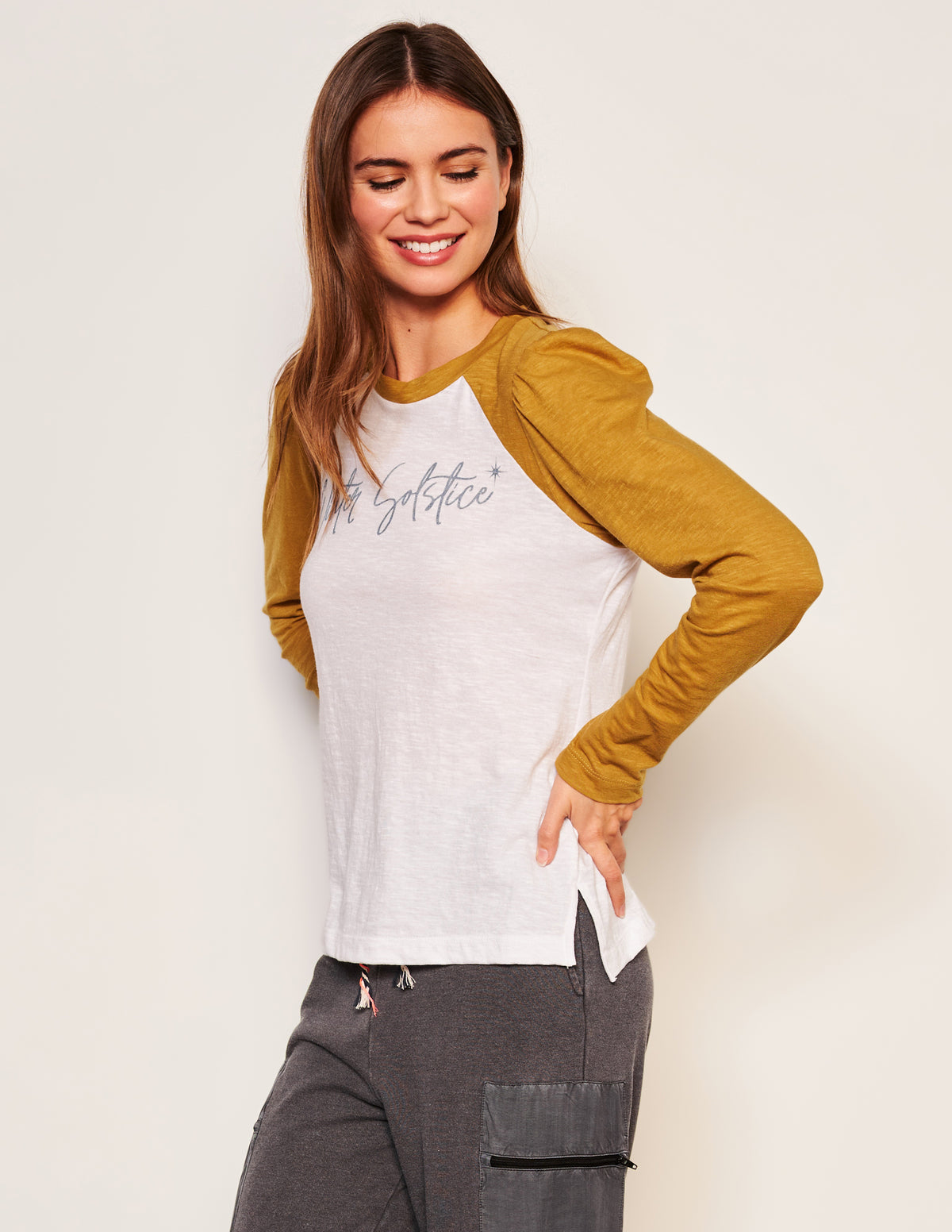 Sundry Winter Solstice Long Sleeve Contrast Sleeve Tee in Optic White-model has her hands on her hips and is looking down