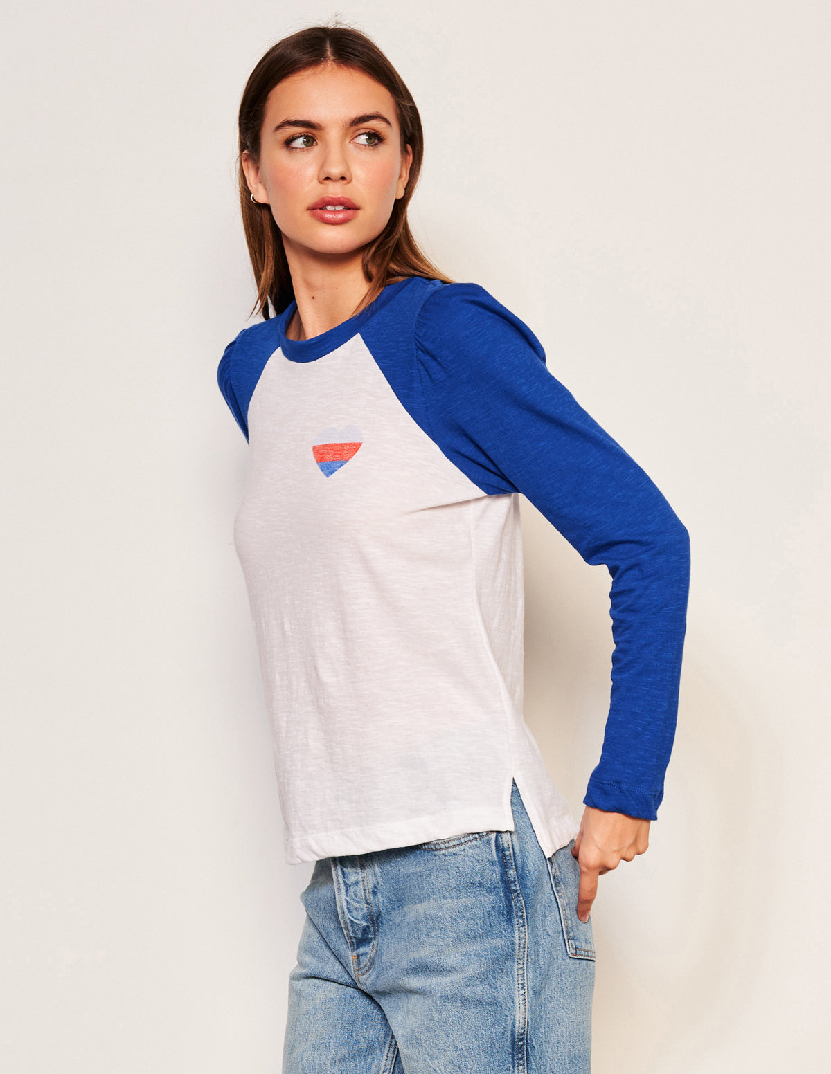 Sundry Heart Long Sleeve Contrast Sleeve Tee in Symphony-model is looking to the side and has her hand on her jean pocket
