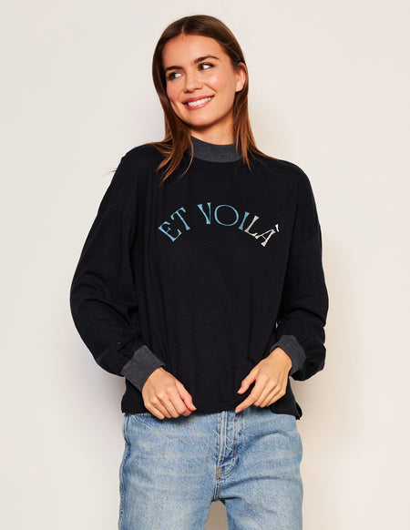 Sundry Et Voila Mock Neck Long Sleeve Tee in Deep Navy-model has her finger in her pockets and is looking down