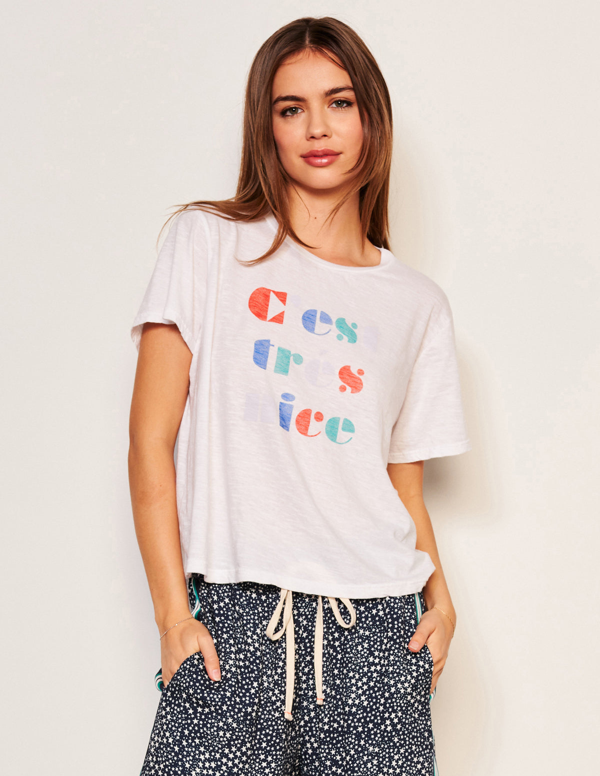 Sundry C&#39;est Crew Neck Tee in Optic White-3/4 front view model has her hands in her pocket