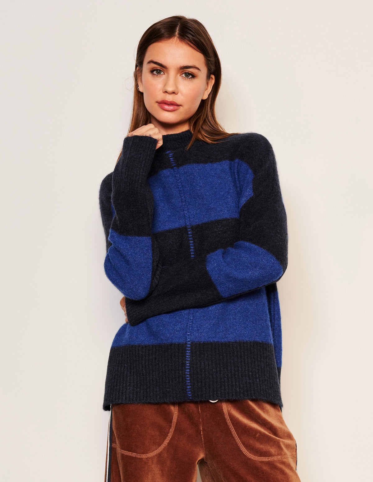 Sundry Bold Stripe Tunic Sweater in Deep Navy-model is folding her hand is has one by her sweater collar