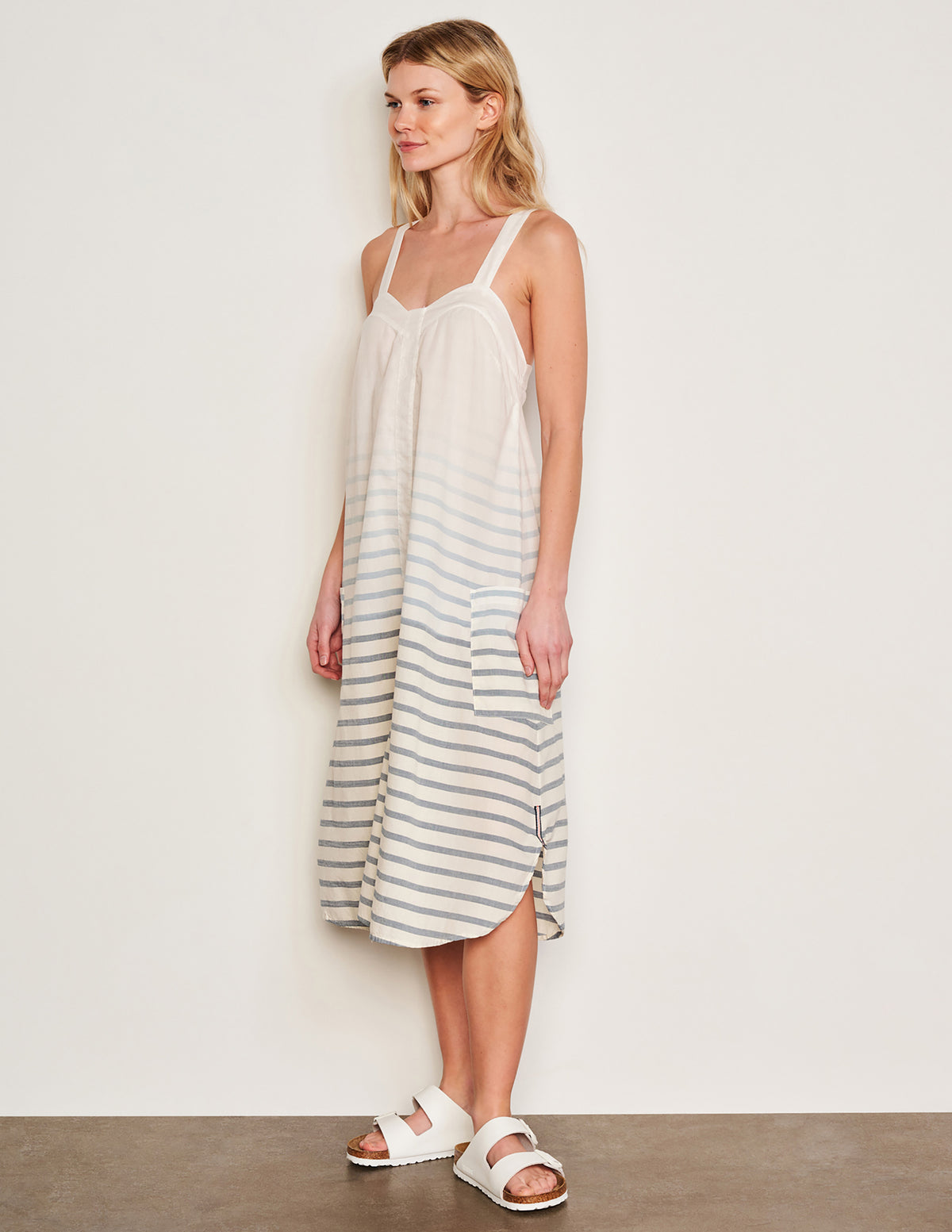 Sundry Changing Tide Stripe Midi Apron Dress in Deep Navy-model side view has her hands resting on the dress pocket