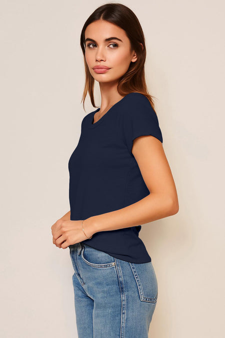 Woman wearing a black t-shirt and blue jeans against a plain background