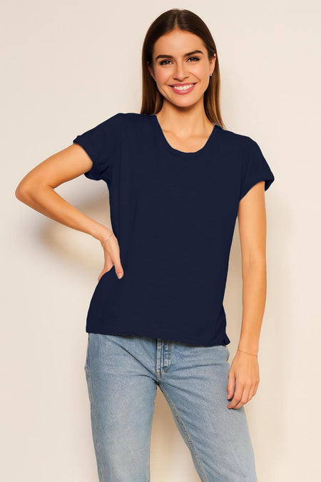 Woman wearing a black t-shirt and blue jeans against a plain background