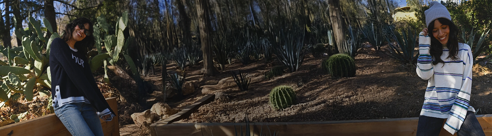 Two people standing in a desert landscape with cacti and rocks.